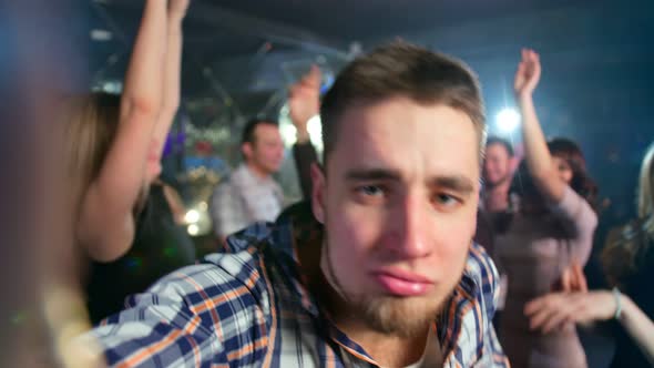 Handsome Guy in a Shirt is Taking a Selfie While Dancing at the Night Club