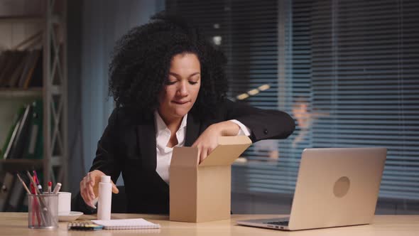 Portrait of African American Woman Taking Out Samples of Cosmetics From a Cardboard Box