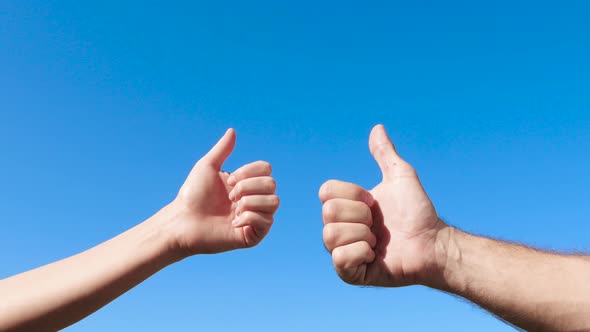 Male and Female Hands on the Background of the Blue Sky Show Gesture-thumbs Up, Class