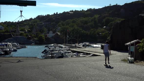 Young guy is longboarding at the docks on the beach in Norway at Kjerringvik