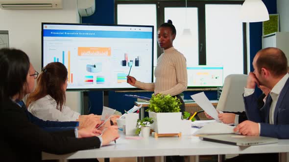 Black Woman Worker Explaning Company Statistics in Front of Colleagues