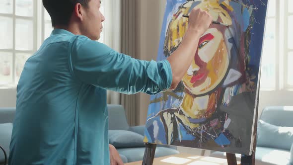 Asian Artist Man In Wheelchair Holding Paintbrush Mixed Colour And Painting A Girl On The Canvas