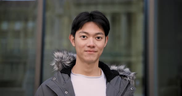Young happy Chinese man portrait smiling and looking at camera
