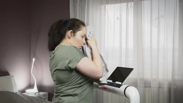 Woman is doing intense running exercises on treadmill at home