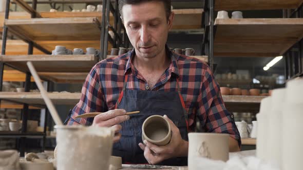 Caucasian Focused Man Making Ceramic Vase in the Pottery