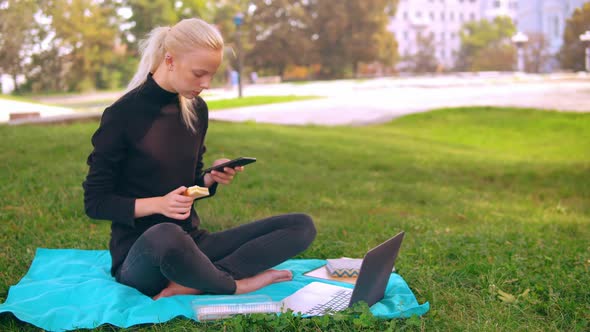 Caucasian Girl Eats and Typing on Laptop Outdoor