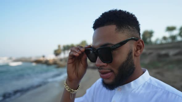 Closeup of Relaxed Bearded Gay Tourist Putting on Sunglasses Admiring Beauty of Sea in Slow Motion