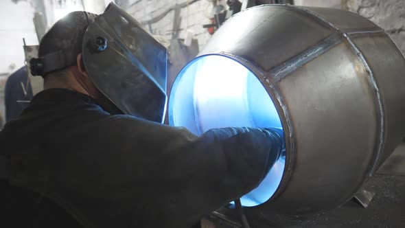Worker in Protective Mask Welding Metal Construction at Industrial Production