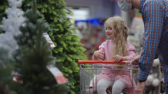 Dad and Child Choose Christmas Toys on the Store Shelf