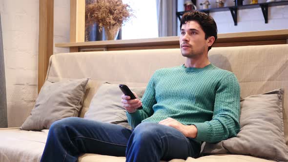 Man Celebrating Online Success While Watching Match on TV