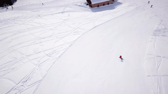 4k aerial footage, drone following skiers on ski slope in skiing region. Skiers skiing downhill the