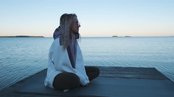 Girl sitting on the pier and talking. Slow motion