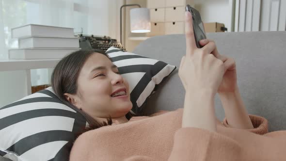 Asian woman holding a smartphone and using online social on lifestyle.