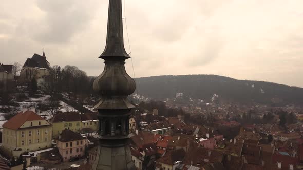 Detail of the tower and roof of the Clock Tower of Sighisoara with the citadel on background on a cl