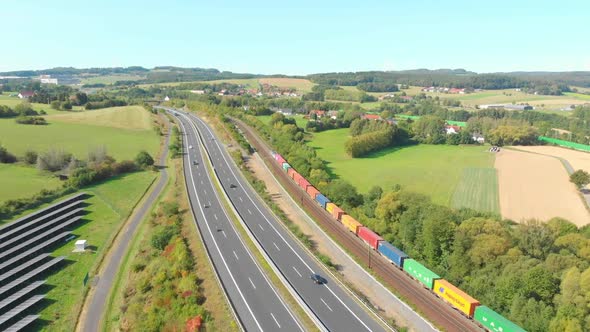 freight train with containers passing through landscape