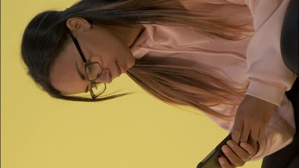 Close-up of Black Woman in Eyeglasses Working on Smartphone.