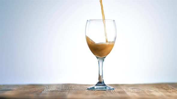 Dark Beer Tapping in Wine Glass on Wooden Table