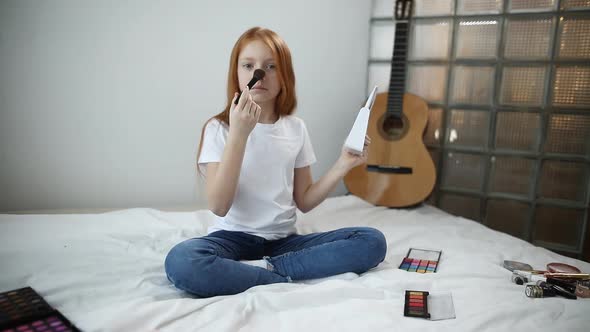 Cute Teen Girl Smiles at the Camera and Tells Her Teen Followers How To Apply Powder To Their Face