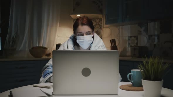 Young Girl In The Kitchen With Laptop. Young Woman Working Remotely At Home Because Of Pandemic