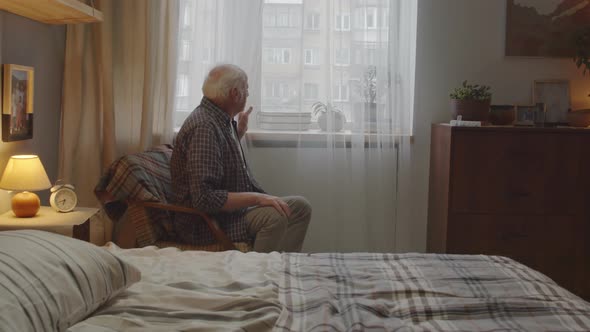 Sad Aged Man Sitting by Window