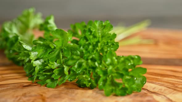 Super Slow Motion Shot of Fresh Parsley Falling on Wooden Cutting Board at 1000Fps