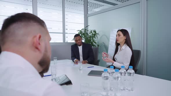 Woman Talking to Colleagues at Business Meeting
