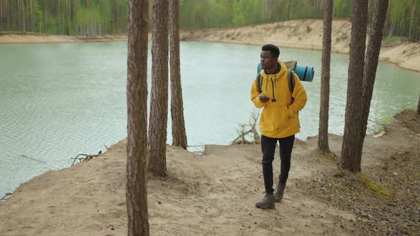 A Black Man is Walking on Top of a Mountain and Typing a Message and Photo on His Smartphone