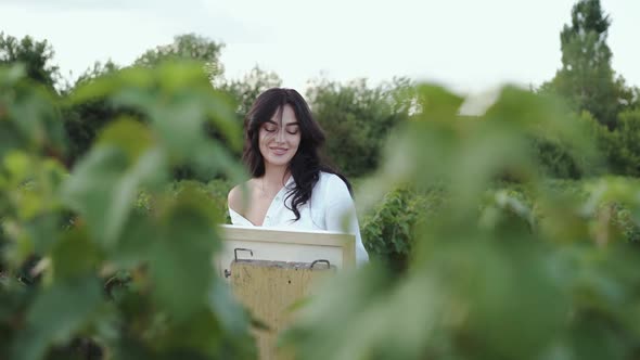 Portrait Through the Bush Branches of Female Artist Rejoices From Painting