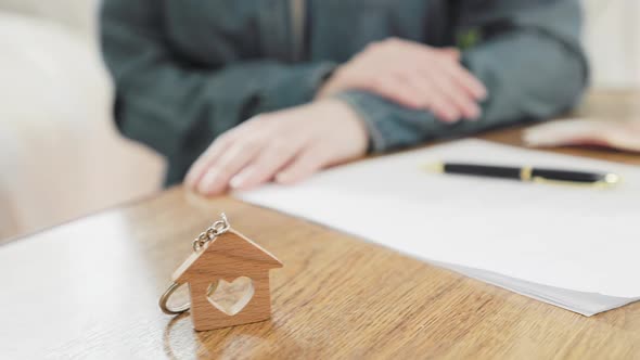 Lawyer woman sitting at a table with documents, money and keys