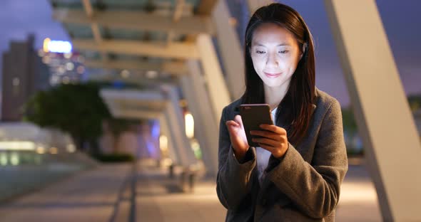 Business woman use of mobile phone in city at night