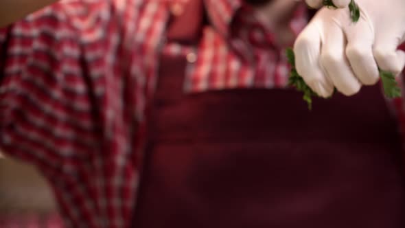 Macro View of Cook Hands in Gloves Who is Ripping and Throwing Fresh Parsley on a Dish