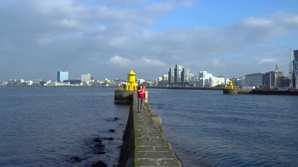 Girl Walks Near the Yellow Lighthouse