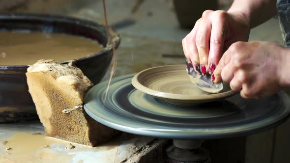 Hands of Female Potter Making Bowl
