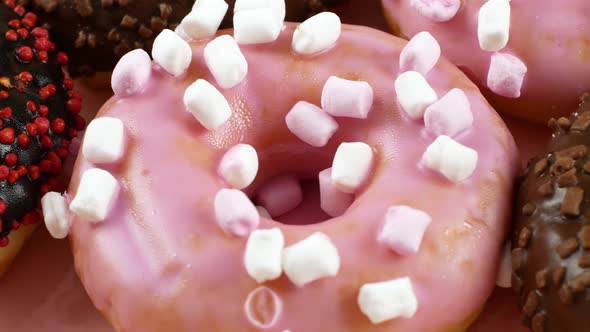 Close-up slider motion donuts. 4k closeup of delicious sweet multicolored donuts