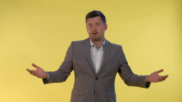 Elegant Man in Suit Spreading Hands To the Sides and Saying "I Don't Know"