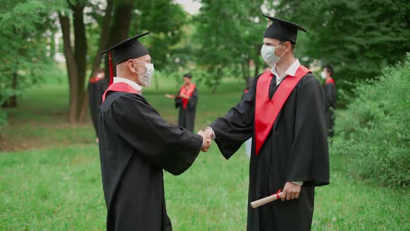 International University Graduation Senior Lecturer Congratulates the Man Student on Receiving Her