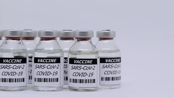 Corona Virus Vaccine In Bottle Over White Background - panning shot