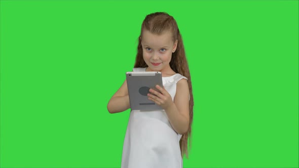 Small Girl Using Tablet Computer on a Green Screen, Chroma Key