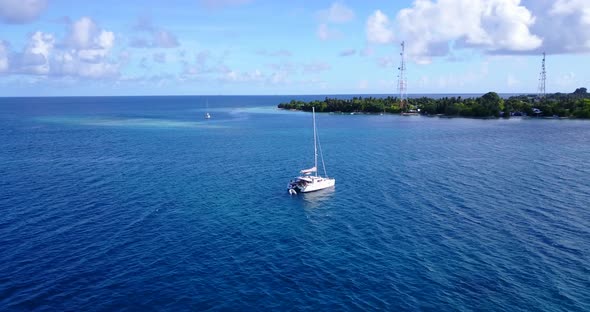 Daytime aerial island view of a sunshine white sandy paradise beach and blue ocean background in hi 