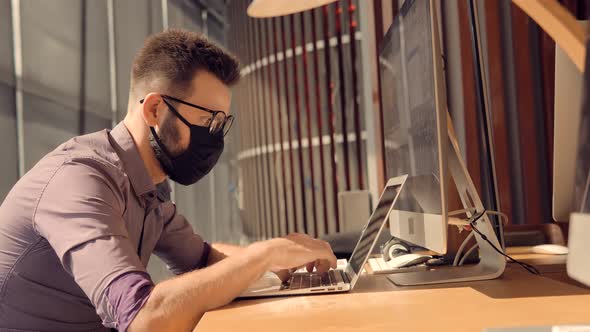 Man In Face Mask Office Workplace On Coronavirus Epidemic. Remote Camera Chatting Colleague Internet