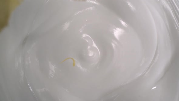 Sliced fresh lemons and lemon peels rain on yogurt - High-angle shot