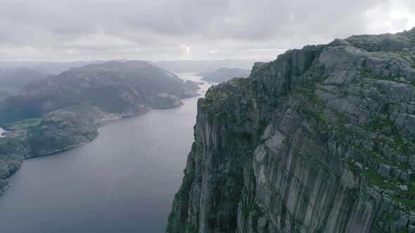 Aerial Slomo shot of Norwegian Mountains, revealing Fjord and a large bridge in the background, duri