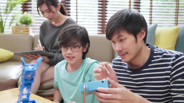 , happy family getting a lesson in coding control robotics at home