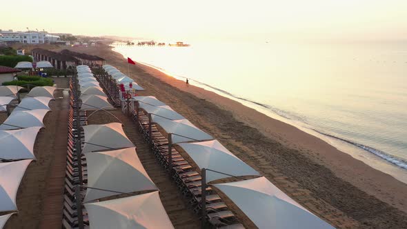 Top View of Sandy Beach with Sunbeds and Sun Umbrellas.