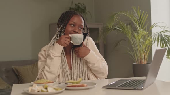 African American Woman Chatting on Phone during Breakfast