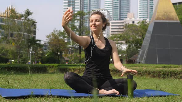 Young Sport Woman Taking Selfie With Smartphone After Practicing Yoga In Park