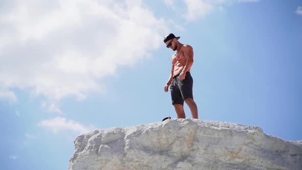 Sportive man training outdoors. View of sportrtive man on top of mountain