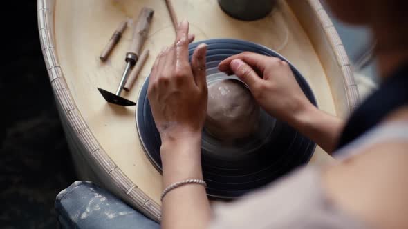 Closeup Hands of Unrecognizable Female Potter Making Ceramic Pot on Twisted Pottery Wheel in Pottery