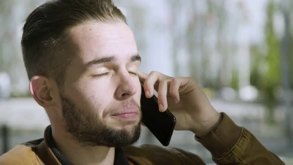 Joyful Bearded Man Talking on Smartphone Outdoor