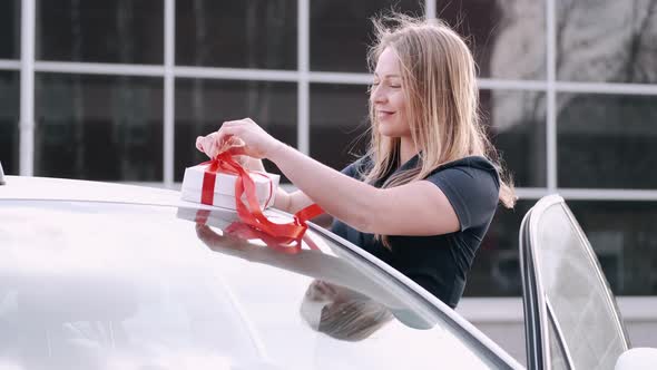 A Beautiful Woman Is Unpacking Her Gift in a Car